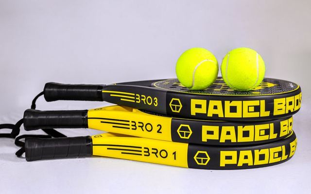 Vibrant padel rackets and tennis balls on white backdrop, ideal for sports themes.